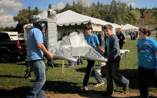 Students carrying their giant duct-tape dragon-bot at Champlain Maker Faire